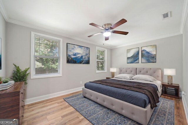 bedroom with light hardwood / wood-style floors, ornamental molding, multiple windows, and ceiling fan