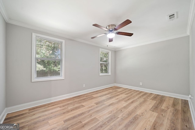 empty room with ornamental molding, light wood-type flooring, and a wealth of natural light