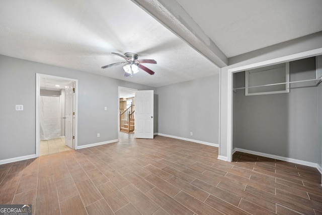 unfurnished bedroom featuring a closet, ceiling fan, a textured ceiling, and ensuite bath