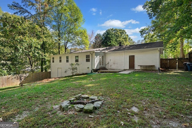 rear view of house featuring a yard