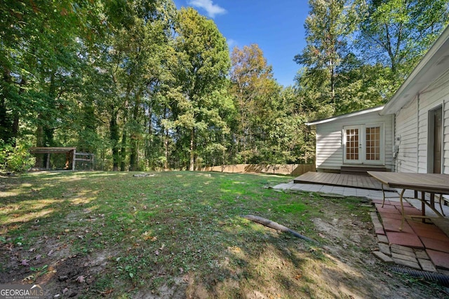 view of yard with french doors and a wooden deck