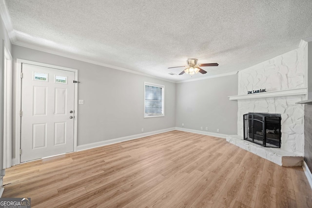 unfurnished living room featuring ornamental molding, a textured ceiling, and light wood-type flooring