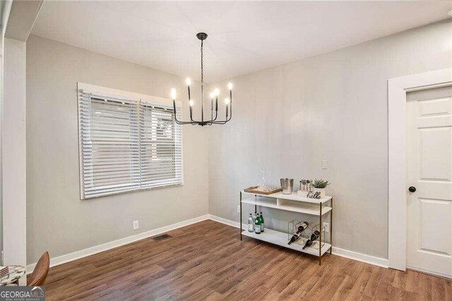 dining space featuring an inviting chandelier and hardwood / wood-style flooring