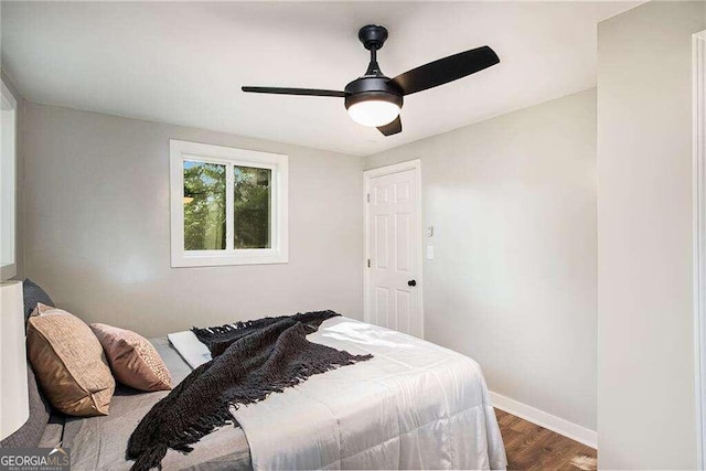 bedroom with baseboards, ceiling fan, and wood finished floors