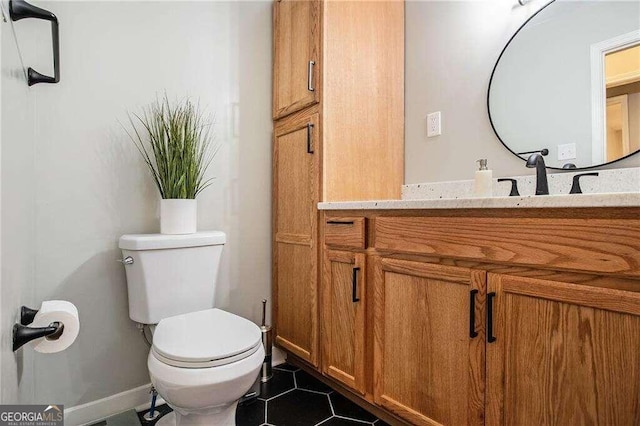 half bath featuring tile patterned flooring, vanity, baseboards, and toilet