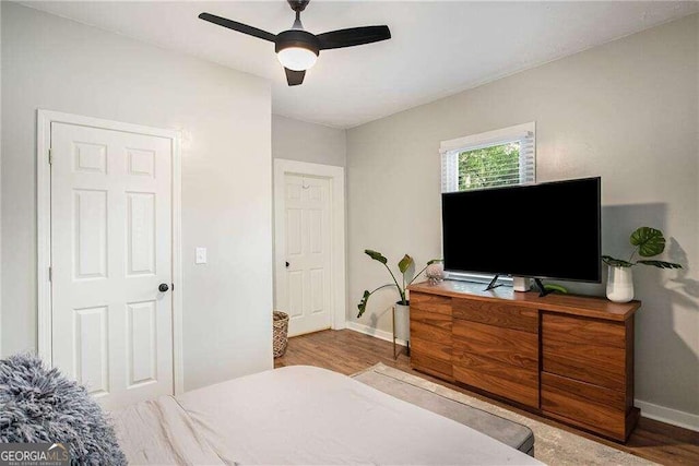 bedroom featuring baseboards, a ceiling fan, and wood finished floors