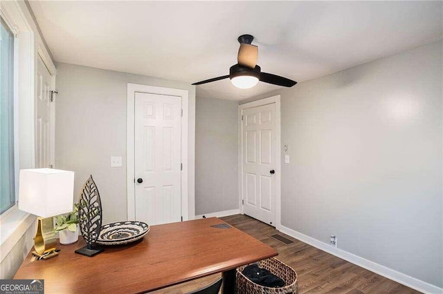 home office featuring visible vents, baseboards, a ceiling fan, and wood finished floors