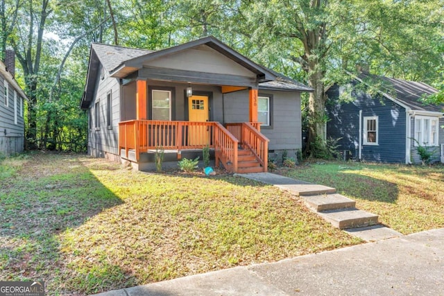 bungalow-style home with covered porch and a front yard