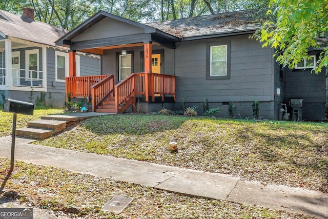 bungalow-style home featuring a front yard and covered porch