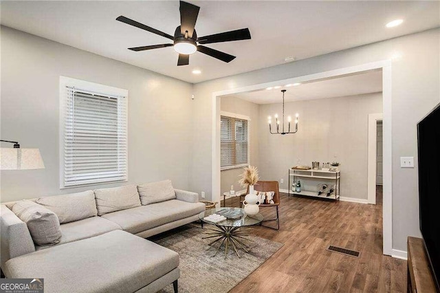 living room with recessed lighting, visible vents, ceiling fan with notable chandelier, and wood finished floors