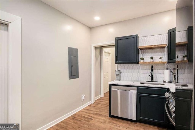 kitchen featuring light wood-type flooring, decorative backsplash, stainless steel dishwasher, sink, and electric panel