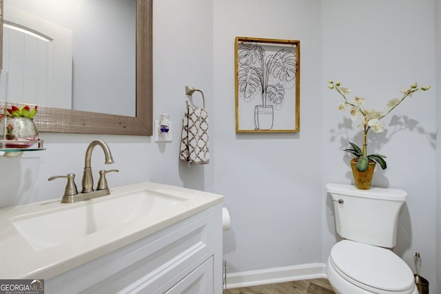 bathroom with vanity, toilet, and hardwood / wood-style flooring