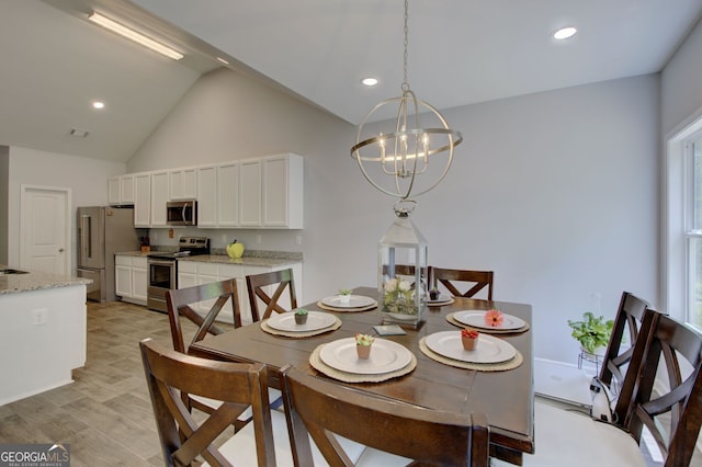 dining area with lofted ceiling and a chandelier