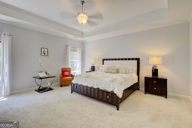 carpeted bedroom featuring ceiling fan, a raised ceiling, and crown molding