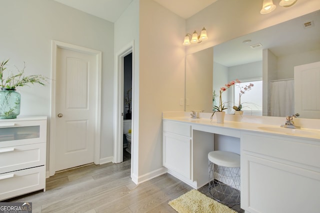 bathroom featuring hardwood / wood-style flooring, vanity, and toilet