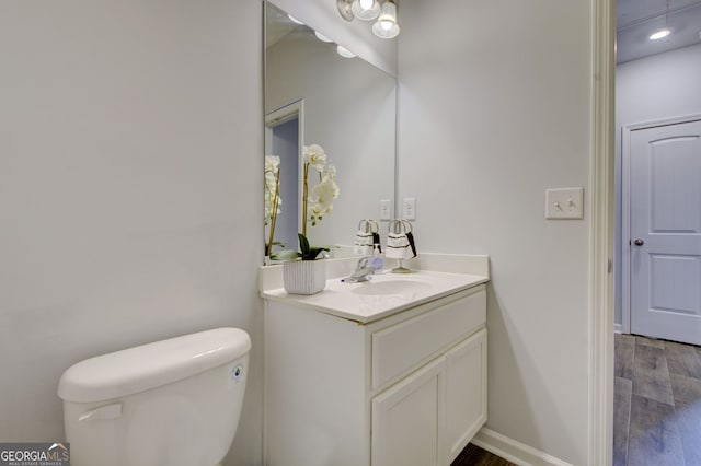 bathroom featuring vanity, hardwood / wood-style flooring, and toilet