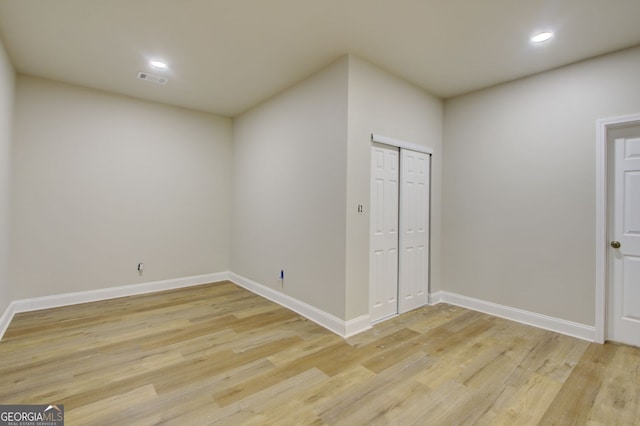 unfurnished bedroom with light hardwood / wood-style flooring and a closet