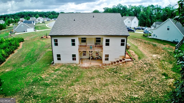 rear view of property featuring a yard, a patio area, and a deck