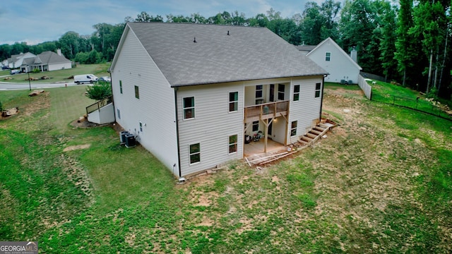 rear view of property with a lawn and central AC