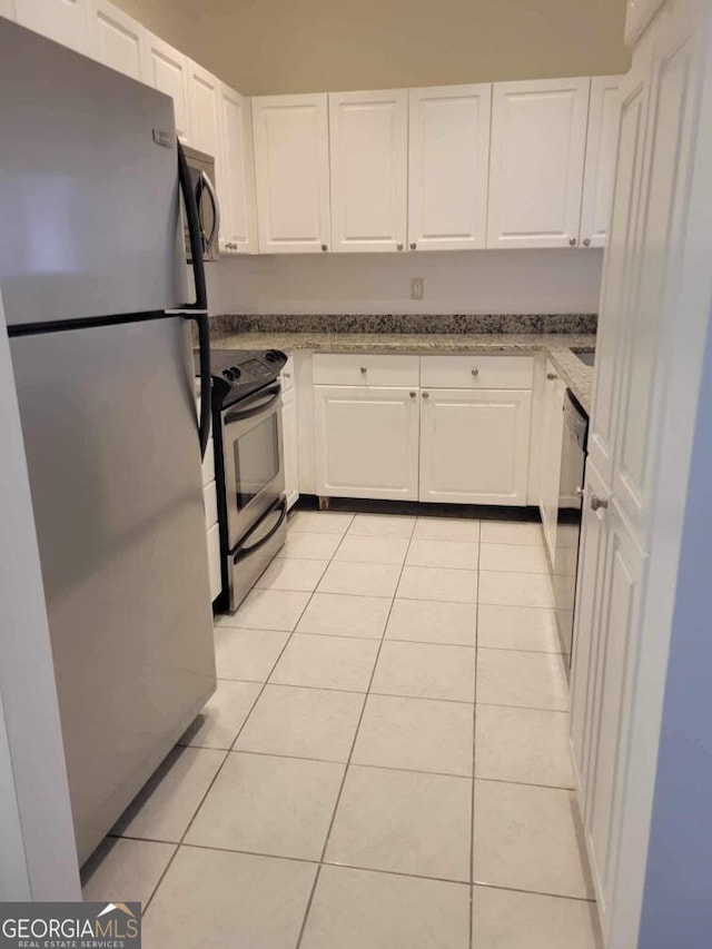 kitchen featuring light tile patterned floors, stainless steel appliances, and white cabinets