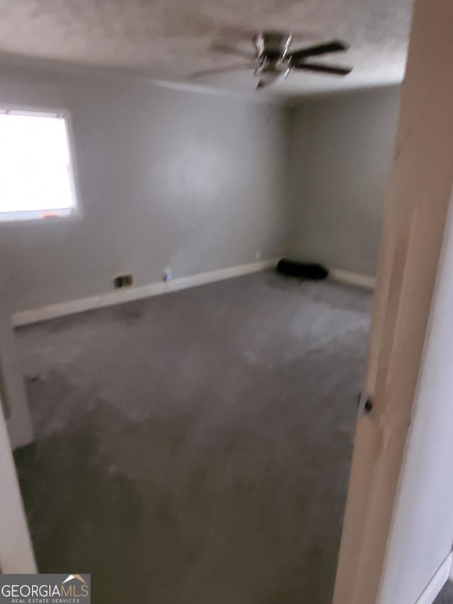 empty room with ceiling fan and carpet floors