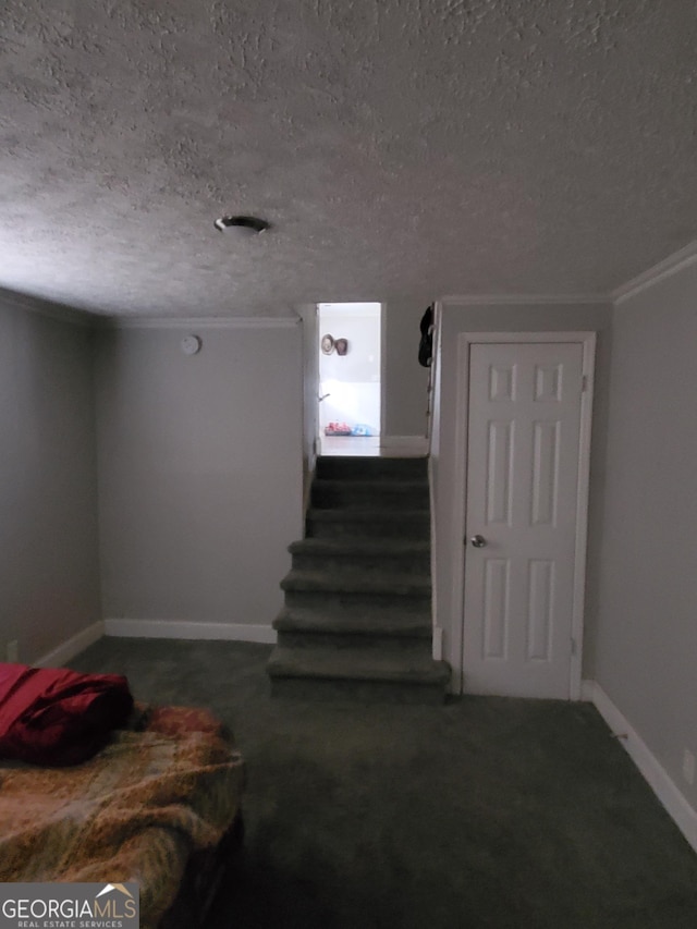 stairway with a textured ceiling and ornamental molding