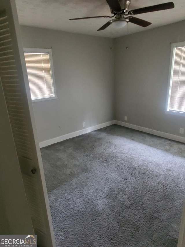 carpeted spare room featuring ceiling fan