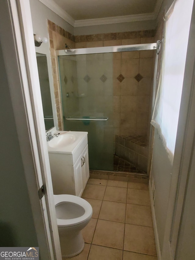 bathroom with tile patterned flooring, toilet, vanity, a shower with shower door, and ornamental molding