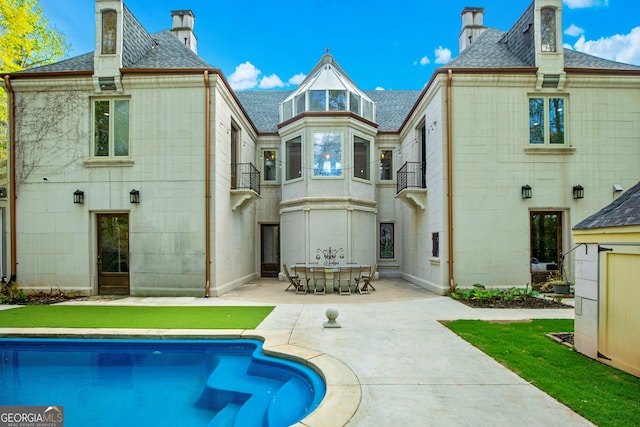 rear view of house featuring a patio area and a balcony