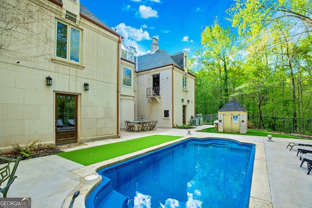 view of pool with a shed, central AC, and a patio