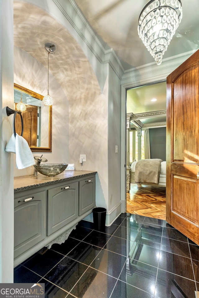 bathroom with vanity, a notable chandelier, and ornamental molding