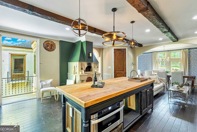 kitchen with dark wood-type flooring, beamed ceiling, and hanging light fixtures