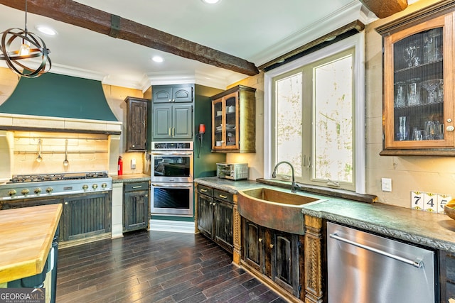 kitchen with beam ceiling, appliances with stainless steel finishes, extractor fan, dark wood-type flooring, and sink