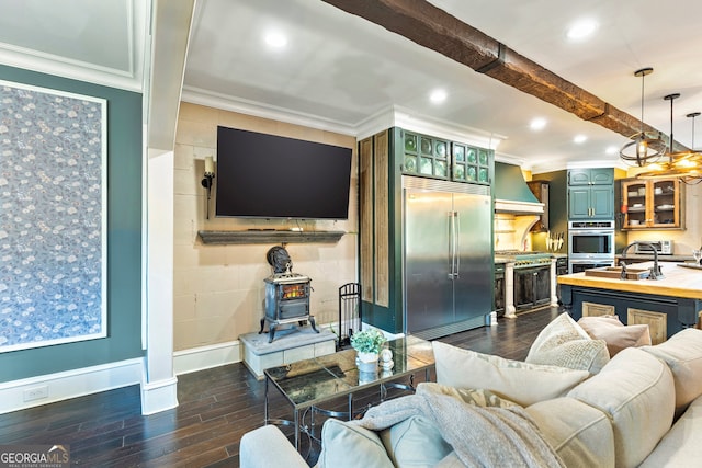 living room featuring dark wood-type flooring, beamed ceiling, ornamental molding, and sink