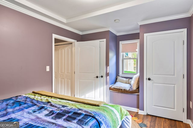 bedroom with ornamental molding, hardwood / wood-style floors, and a closet