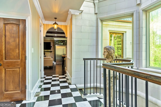 corridor featuring ornamental molding and a healthy amount of sunlight