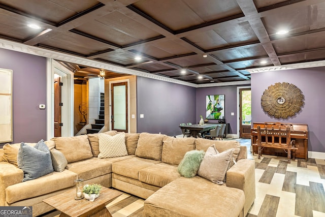 living room with coffered ceiling, ornamental molding, beamed ceiling, and light wood-type flooring