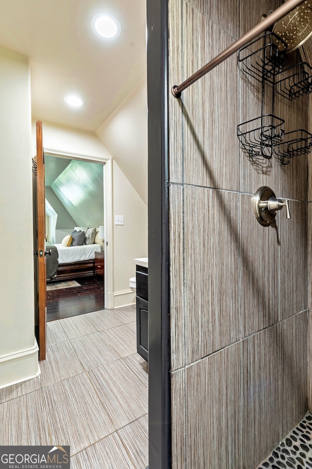 bathroom featuring vanity, lofted ceiling, walk in shower, and wood-type flooring