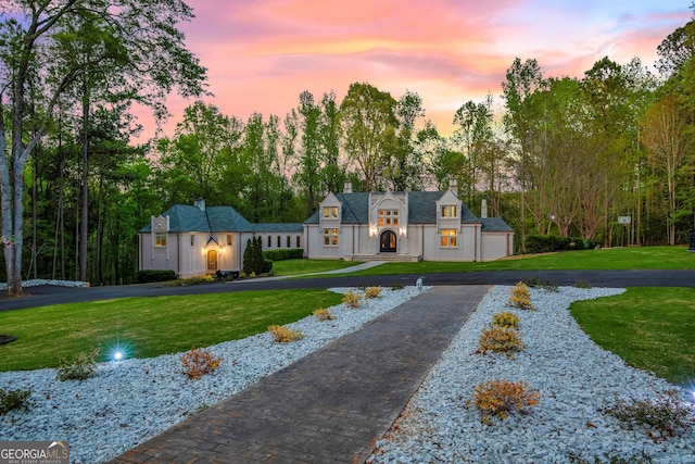 view of property's community featuring a lawn and a garage