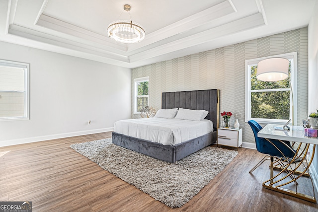 bedroom with wood-type flooring and a raised ceiling