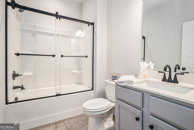 full bathroom featuring shower / bath combination with glass door, toilet, tile patterned flooring, and vanity