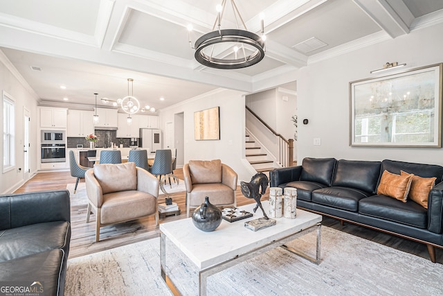 living room featuring coffered ceiling, crown molding, hardwood / wood-style floors, and a chandelier