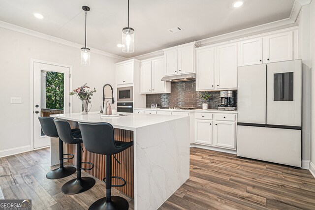 kitchen featuring a kitchen island with sink, white cabinetry, stainless steel appliances, and dark hardwood / wood-style flooring