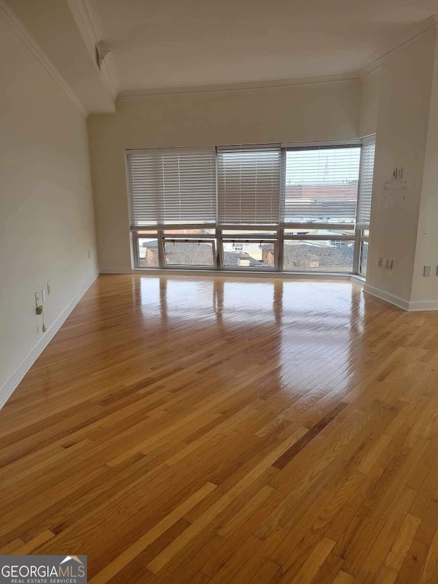 unfurnished room featuring light wood-type flooring and ornamental molding