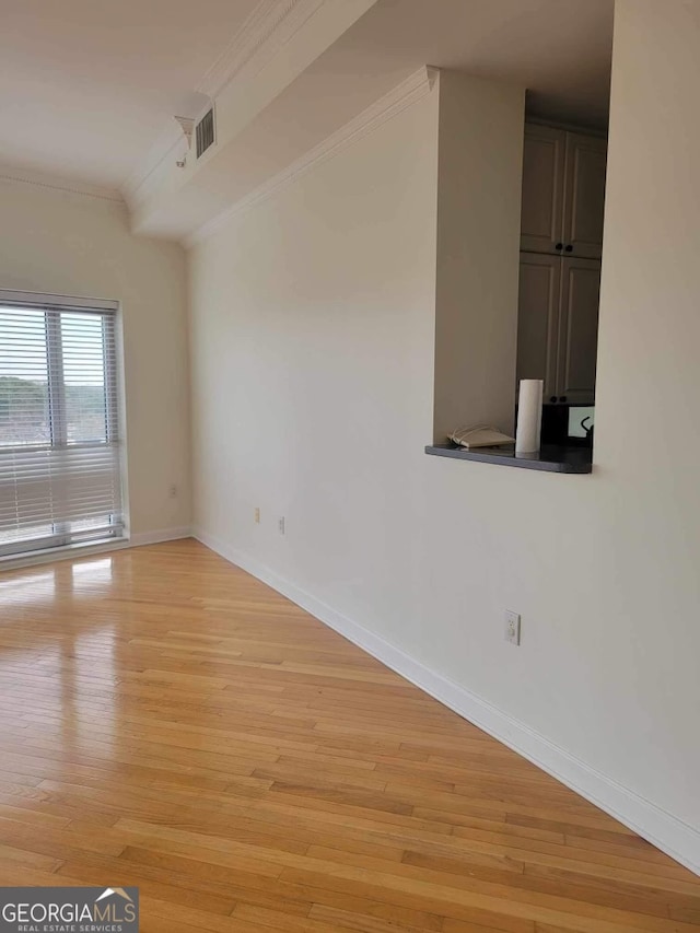 unfurnished room featuring light hardwood / wood-style floors and crown molding