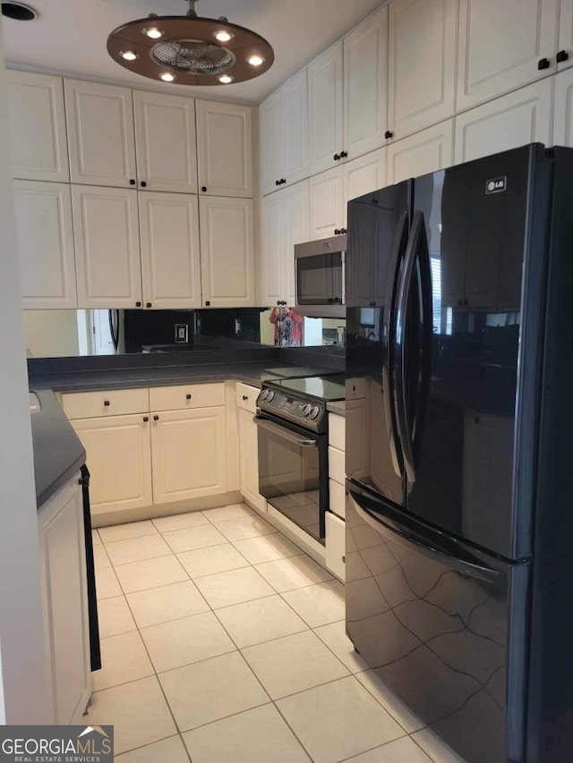 kitchen with white cabinets, light tile patterned floors, and black appliances