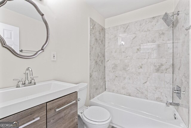 full bathroom featuring vanity, toilet, and tiled shower / bath