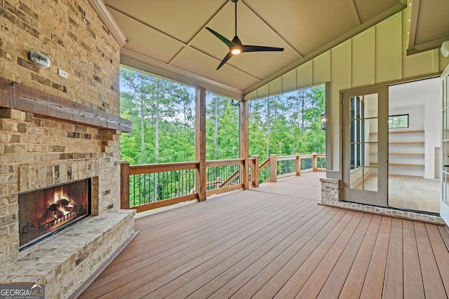 wooden deck with ceiling fan and an outdoor brick fireplace