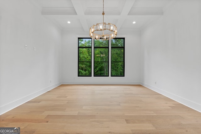 empty room featuring coffered ceiling, a chandelier, light hardwood / wood-style flooring, ornamental molding, and beam ceiling