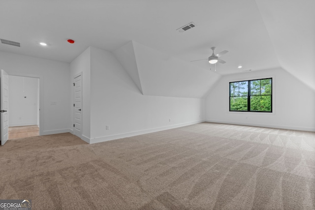 additional living space featuring ceiling fan, vaulted ceiling, and light colored carpet